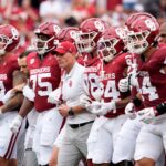 Oklahoma coach Brent Venables leads his team out onto the field.